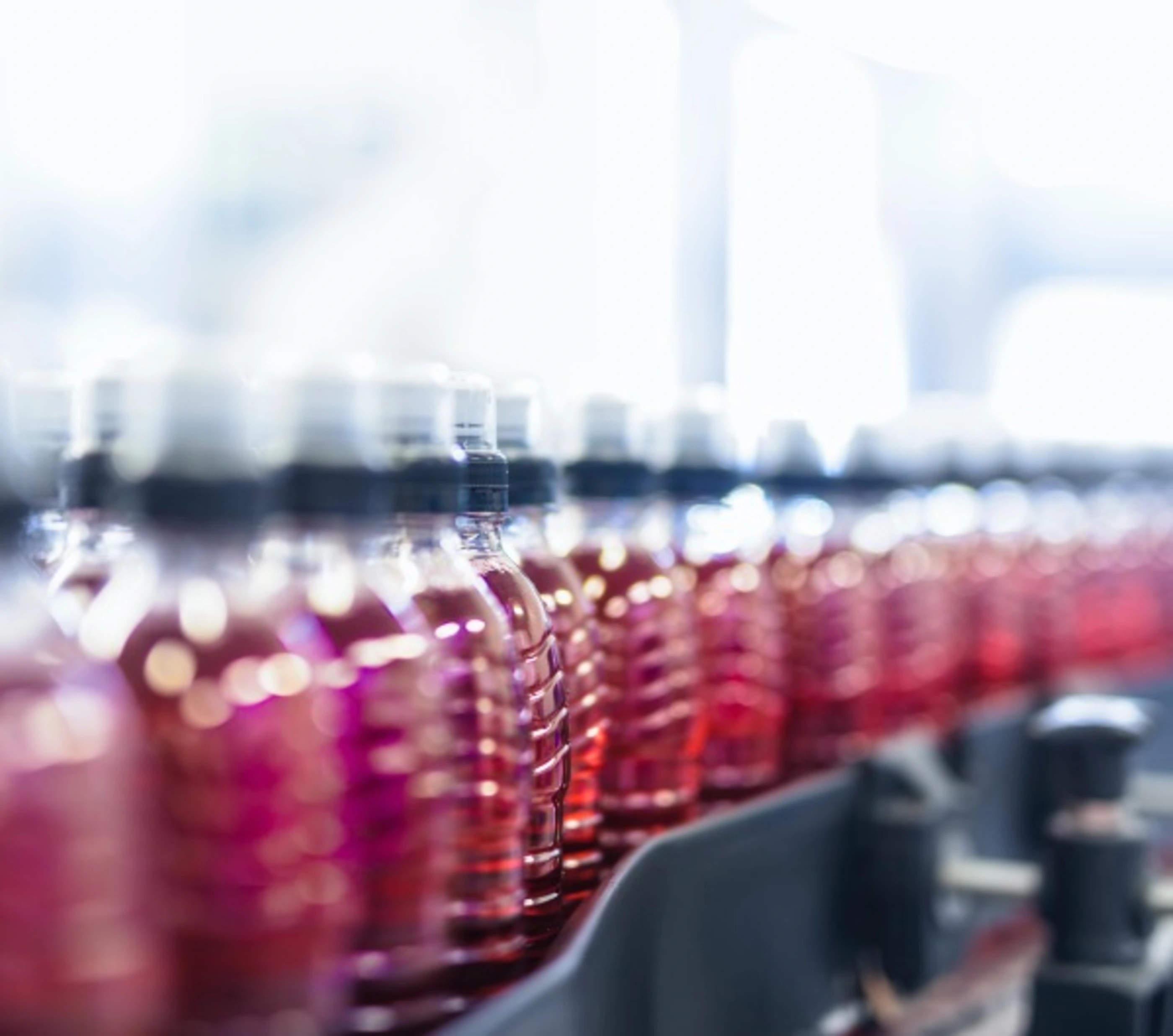 Bottles of a red beverage on a production line
