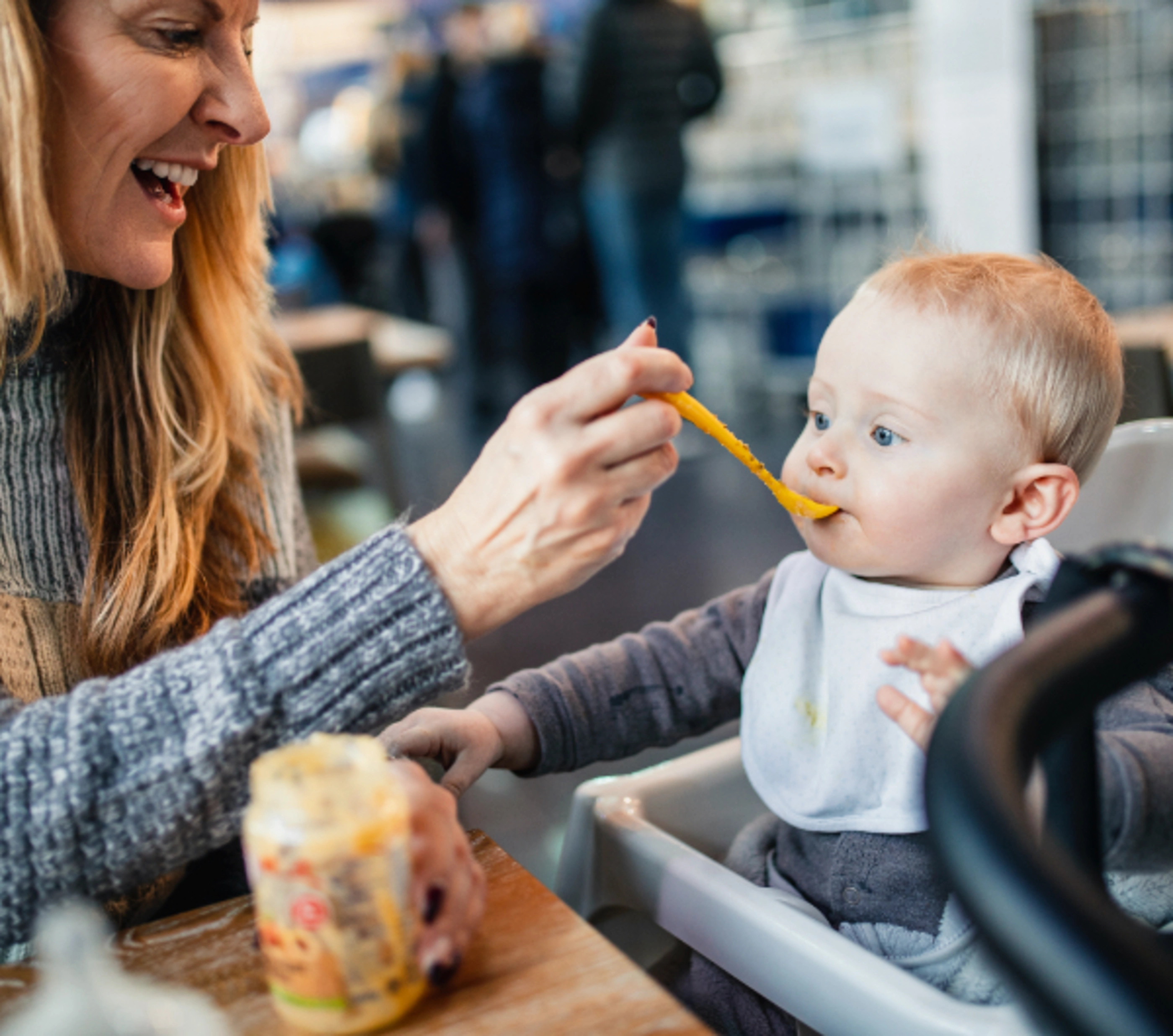 a woman feeding child with a spoon