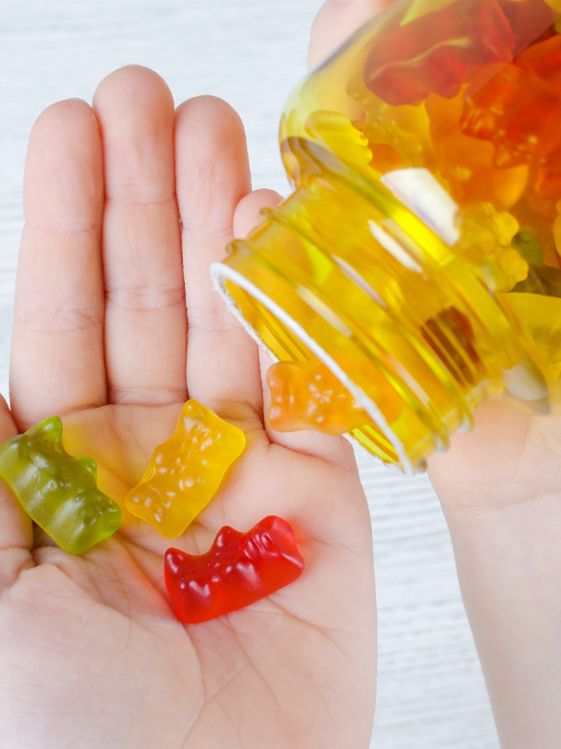 A person pouring gummy bears into their open hand.