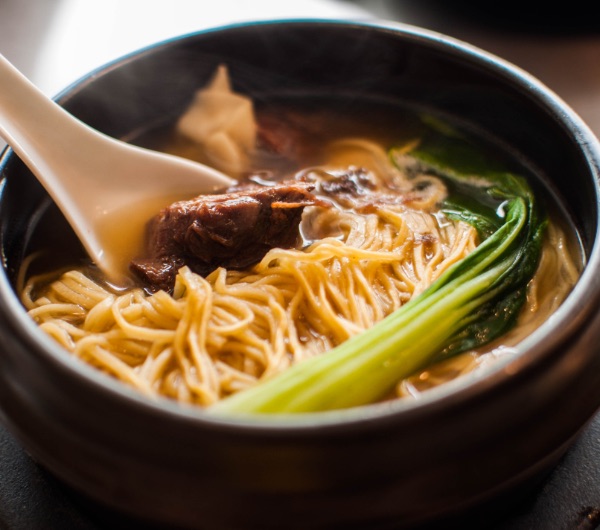 bowl of ramen noodles in broth with beef