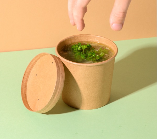 disposable brown paper to-go cup full of ramen noodles in broth
