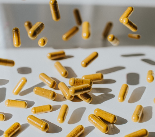 brown capsules falling on a white surface