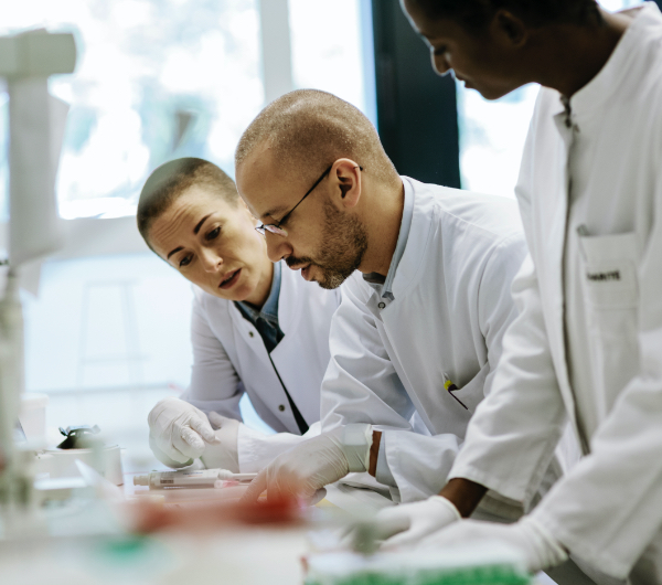Three scientists looking down at a piece of paper