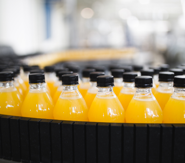 orange beverage in bottles with black caps