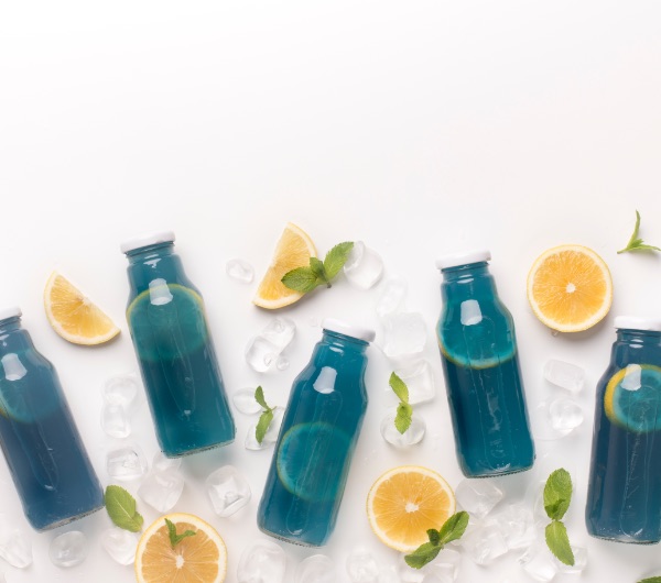 blue liquid in glass bottles with white caps